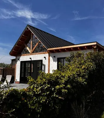 a small white house with a black door at Rustic Lake House in Vinkeveen