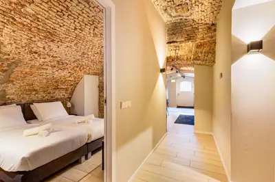 a bedroom with a bed and a brick wall at 4P Unique canal apartment A Location in Utrecht in Utrecht