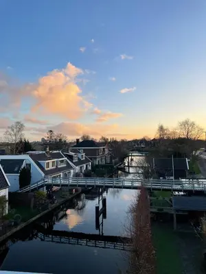 a bridge over a river with houses and buildings at Luxe Wellness Suite Zaandam - Amsterdam in Zaandam