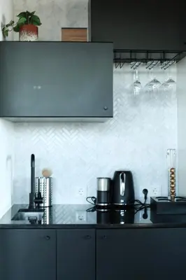 a kitchen with a black counter top and a white wall at Luxe Wellness Suite Zaandam - Amsterdam in Zaandam