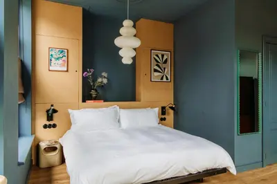 a bedroom with a white bed and a blue wall at LeLou in Utrecht