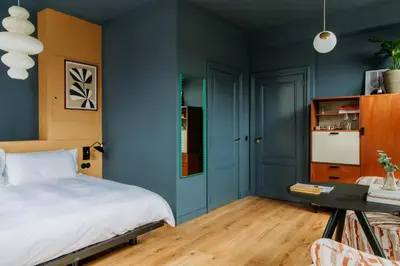 a bedroom with blue walls and a bed and a table at LeLou in Utrecht