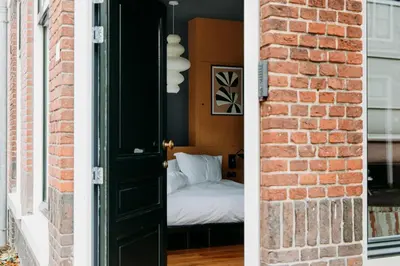 a room with a bed and a brick wall at LeLou in Utrecht