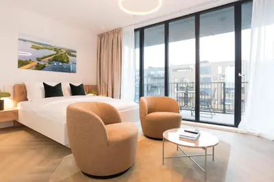 a hotel room with a bed and two chairs at LevelUp Amsterdam in Amsterdam