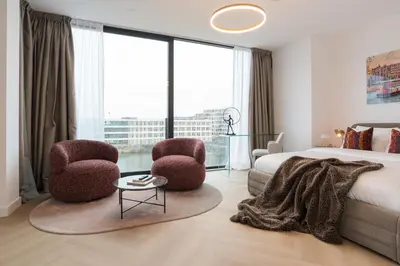 a bedroom with a bed and two chairs and a table at LevelUp Amsterdam in Amsterdam