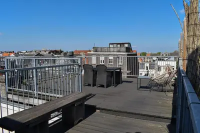 a wooden deck with a bench on top of a building at NEW Roof terrace apartment in Jordaan Area in Amsterdam