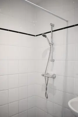 a shower in a white tiled bathroom with a sink at NEW Roof terrace apartment in Jordaan Area in Amsterdam