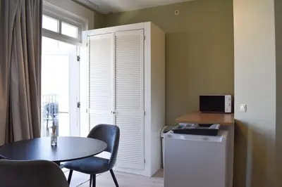 a small room with a table and a table and a window at NEW Roof terrace apartment in Jordaan Area in Amsterdam