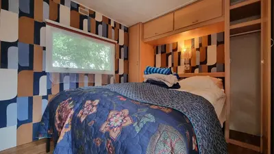 a bedroom with a bed with a blanket on it at City Farmer Farmyard Stays, Sleep Easy, Stay Rural, Explore Amsterdam in Amsterdam