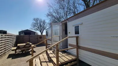 a deck with a door on the side of a house at City Farmer Farmyard Stays, Sleep Easy, Stay Rural, Explore Amsterdam in Amsterdam