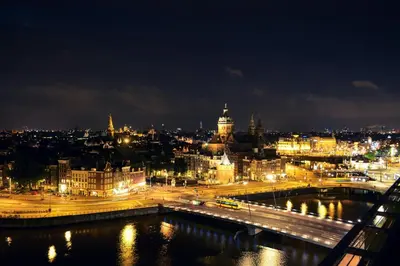 a view of a city at night with lights at City Farmer Farmyard Stays, Sleep Easy, Stay Rural, Explore Amsterdam in Amsterdam