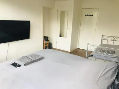 a bedroom with a white bed with a tv on the wall at Canalview Amsterdam in Amsterdam