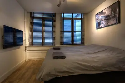 a bedroom with a large bed and two windows at Canalview Amsterdam in Amsterdam