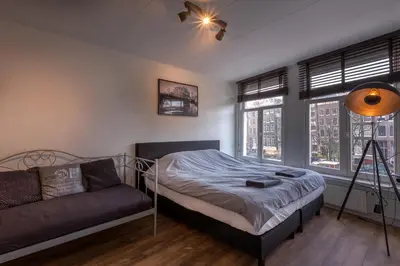 a bedroom with a bed and a couch in it at Canalview Amsterdam in Amsterdam