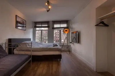 a bedroom with a bed and a couch in it at Canalview Amsterdam in Amsterdam