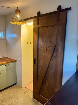 a large wooden door in a kitchen next to a counter at Wanderlust - Vlakbij strand - Omheinde privétuin in Noordwijk aan Zee