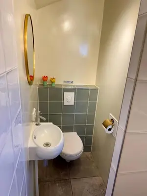 a bathroom with a sink and a toilet and a mirror at Wanderlust - Vlakbij strand - Omheinde privétuin in Noordwijk aan Zee