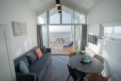 a living room with a couch and a table at overnachtingopstrand in Katwijk