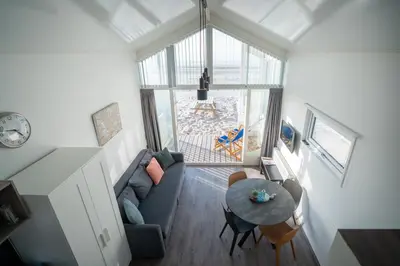 a living room with a couch and a table at overnachtingopstrand in Katwijk