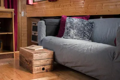 a living room with a gray couch and a wooden table at Houseboat Vinkeveen in Vinkeveen