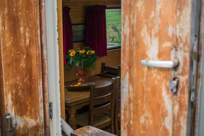a dining room with a table with a vase of flowers at Houseboat Vinkeveen in Vinkeveen