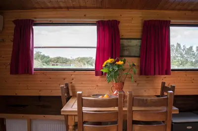 a dining room table with a vase of flowers on it at Houseboat Vinkeveen in Vinkeveen