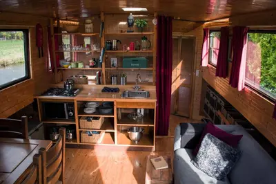a kitchen with a couch and a sink in a room at Houseboat Vinkeveen in Vinkeveen