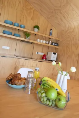 a table with a bowl of fruit and a plate of bread at Lakehouses luxe family holiday house 6 pers in Oud-Ade