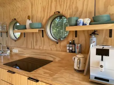 a kitchen with wooden walls and a counter with a sink at Lakehouses luxe family holiday house 6 pers in Oud-Ade