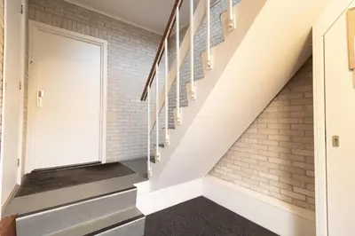 a staircase in a house with a white brick wall at Strand appartement aan zee met 2 parkeerplekken! in Egmond aan Zee