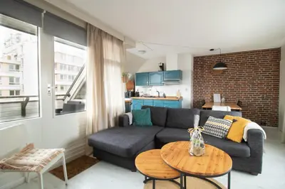 a living room with a couch and a table at Strand appartement aan zee met 2 parkeerplekken! in Egmond aan Zee