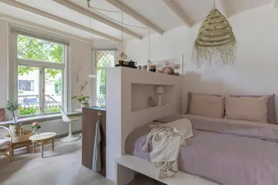 a bedroom with a purple bed in a room with windows at Villa Magnolia in Bergen