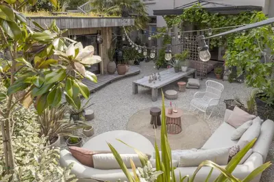 a patio with white couches and tables and plants at Villa Magnolia in Bergen