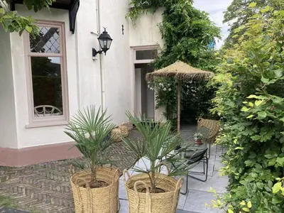 a patio with two potted plants next to a building at Villa Magnolia in Bergen