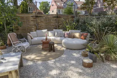 a patio with a white couch and some plants at Villa Magnolia in Bergen