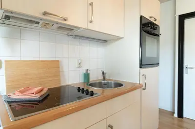 a kitchen with a sink and a counter top at Knus appartement met parkeerplek en zeezicht! in Egmond aan Zee