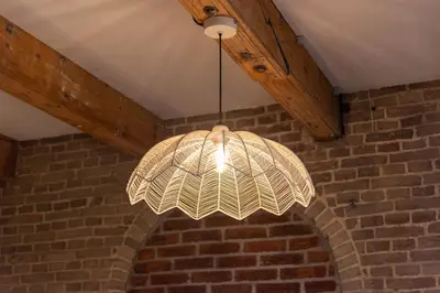 a pendant light hanging from a brick wall at Studio Urbain by Grapèlli Boutique Hotel in Alkmaar