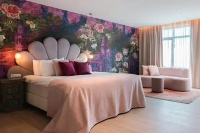 a bedroom with a large bed with a floral wall at Van der Valk Hotel Houten Utrecht in Houten