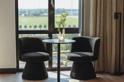 two chairs and a table in front of a window at Van der Valk Hotel Houten Utrecht in Houten
