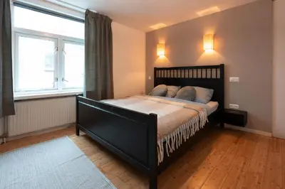 a bedroom with a large bed and a window at Beautiful Beach Holiday Home with Sauna and Garden in Wijk aan Zee