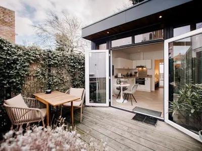 an open patio with a wooden table and chairs at Suite 55, near the beach in Zandvoort