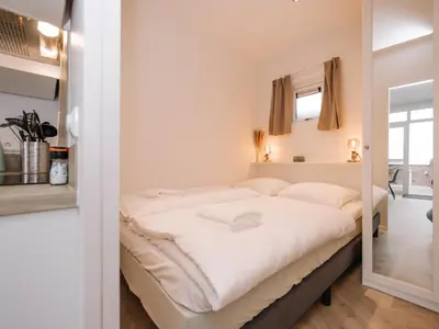 a bedroom with a large white bed in a room at Suite 55, near the beach in Zandvoort