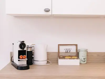 a kitchen counter with a coffee mixer and a box of food at Suite 55, near the beach in Zandvoort