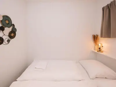 a bedroom with white walls and two beds at Suite 55, near the beach in Zandvoort
