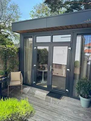 a garden room with sliding glass doors on a deck at Suite 55, near the beach in Zandvoort