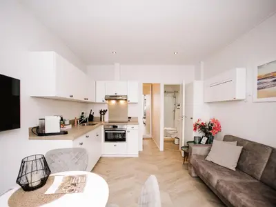 a kitchen and living room with a couch and a table at Suite 55, near the beach in Zandvoort