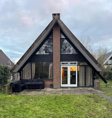 a house with a pitched roof with a couch at Lovely house till 9 pers near Amsterdam and the sea in Opmeer