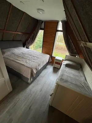 a bedroom with two beds and a large window at Lovely house till 9 pers near Amsterdam and the sea in Opmeer