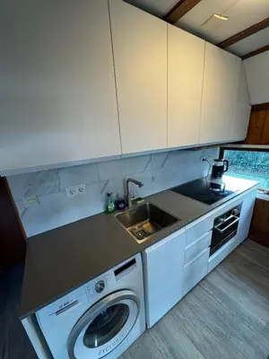 a kitchen with a sink and a washing machine at Lovely house till 9 pers near Amsterdam and the sea in Opmeer