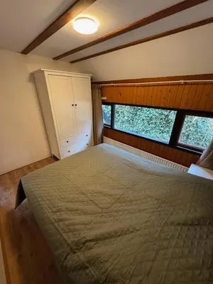 a bedroom with a large bed and two windows at Lovely house till 9 pers near Amsterdam and the sea in Opmeer
